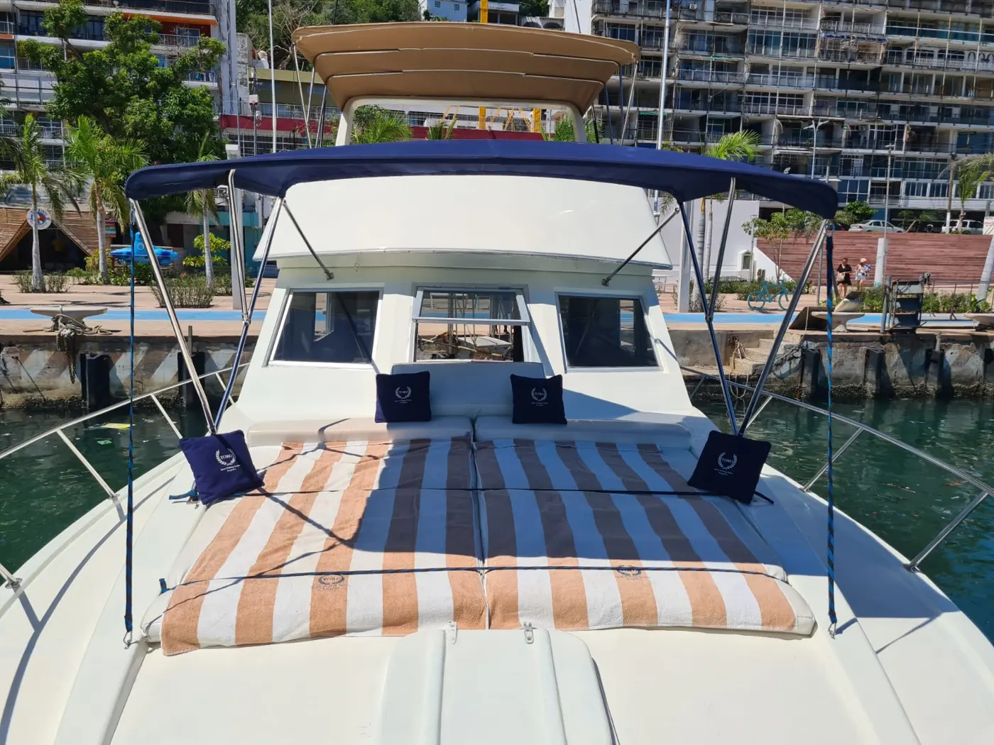 Proa del yate Toro con cojines, toallas y toldo azul