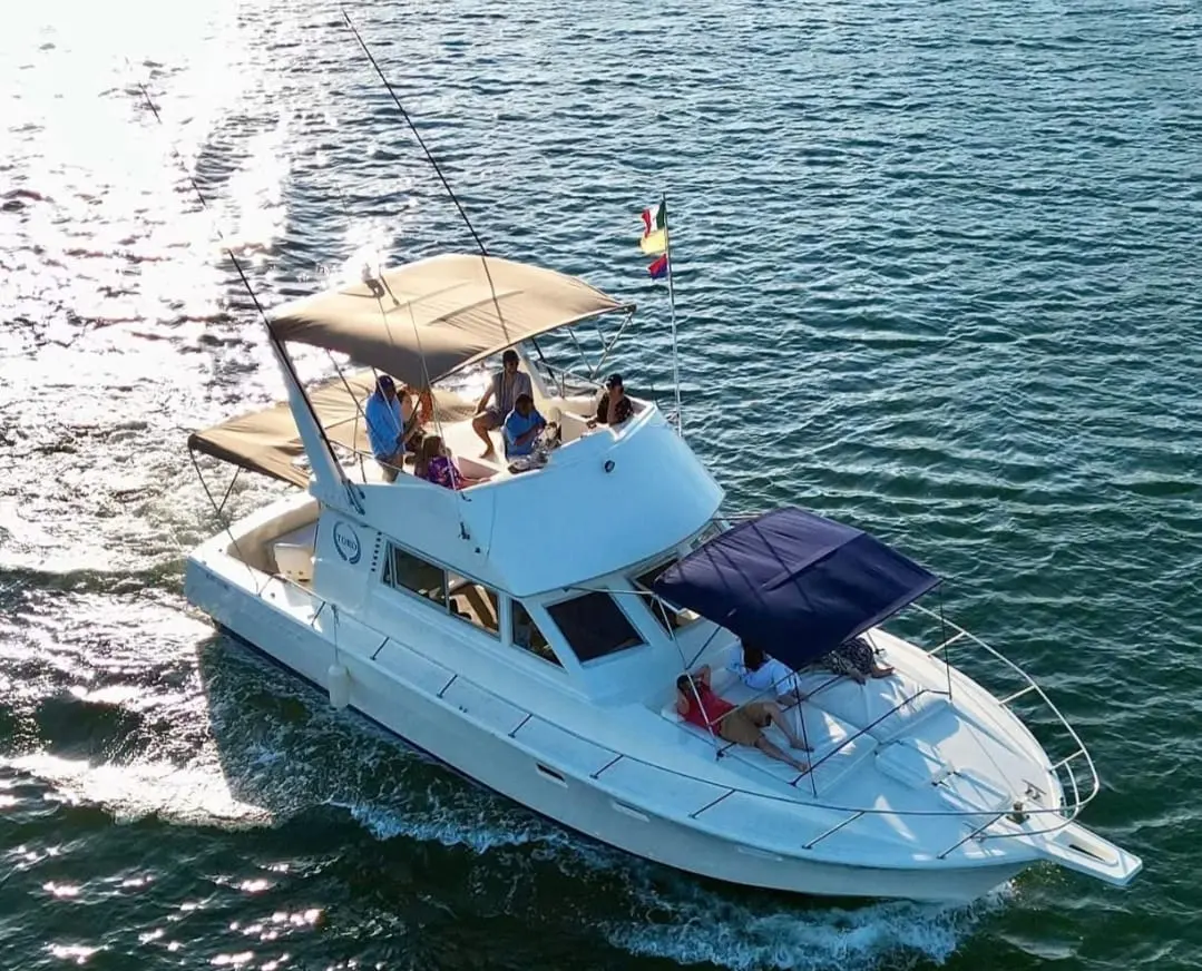Yate Toro navegando al atardecer en la bahía de Acapulco